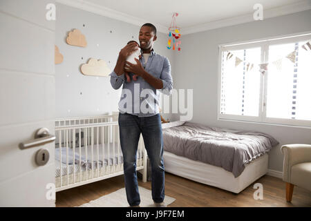 Vater Holding Newborn Baby Sohn im Kindergarten Stockfoto