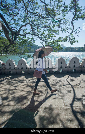 Eine junge Frau Spaziergänge entlang der Promenade direkt am See in Kandy, Sri Lanka Stockfoto