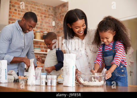 Eltern und Kinder gemeinsam backen Kuchen In Küche Stockfoto