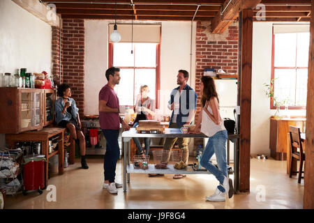 Fünf Freunde im Gespräch über Kaffee in der Küche, in voller Länge Stockfoto