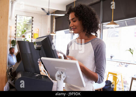 Kellnerin an Kasse In Coffee-Shop Stockfoto