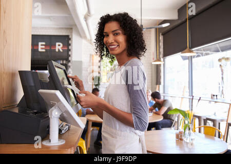 Porträt der Kellnerin an Kasse In Coffee-Shop Stockfoto