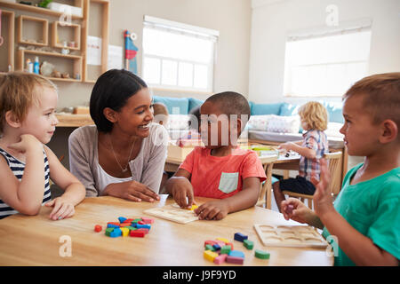 Lehrer und Schüler mit Formen aus Holz In der Montessori-Schule Stockfoto