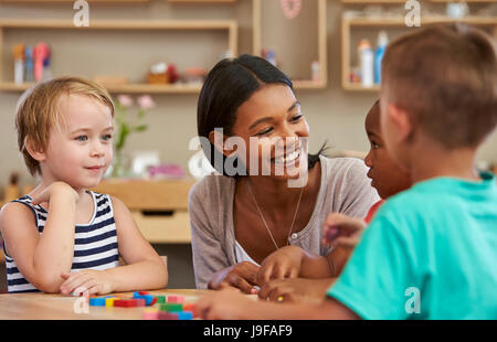 Lehrer und Schüler mit Formen aus Holz In der Montessori-Schule Stockfoto