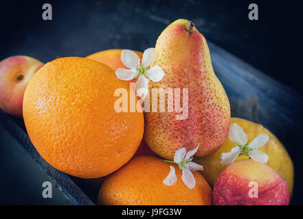 Früchte-Orangen-Grapefruit-Pfirsiche sind in der Box-Nahaufnahme. Die horizontalen Rahmen. Stockfoto