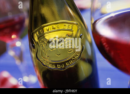 COTES DU RHONE Flasche mit Relief geprägte Bezeichnung Côtes du Rhône roten Wein und Gläser auf Tisch im freien Stockfoto