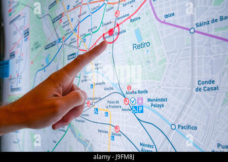 Hand des Mannes zeigte auf einen Punkt auf einer Metro-Karte. Madrid, Spanien. Stockfoto