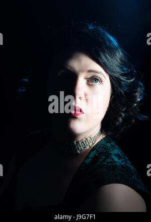 Womans Portrait mit dramatische Beleuchtung mit halben Gesicht im Schatten Stockfoto