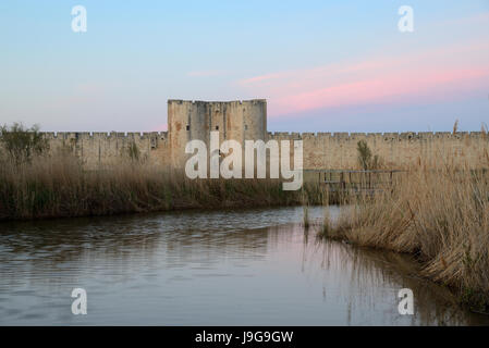 Dämmerung und Sonnenuntergang über mittelalterliche Stadtmauer des mittelalterlichen Mauern umgebene Stadt von Aigues-Mortes Camargue Frankreich Stockfoto