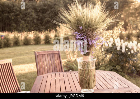 Ein Blumenstrauß von Wildblumen auf einem Holztisch im Garten Stockfoto