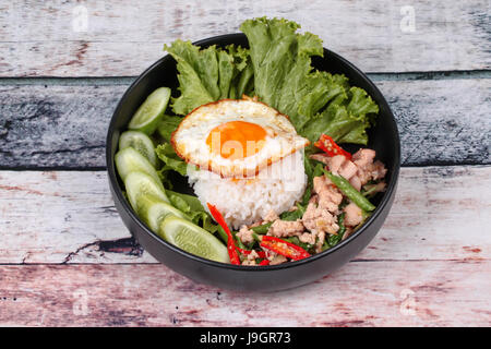 Beliebte thailändische, Jasminreis gekrönt rühren - würziger Basilikum mit Garnelen, Tintenfisch und knusprige Hähnchen gebraten und gebratenem Ei Anruf Kao Pad Kra Prao Kai. Stockfoto