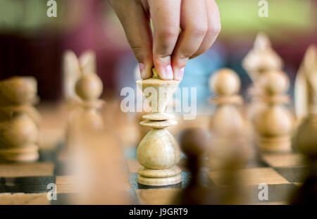 Nahaufnahme von Kinderhand berühren den König des Schachspiels Stockfoto