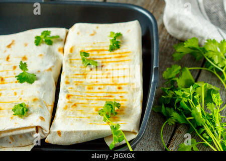 Vegetarische Burritos Wraps mit Bohnen, Avocado und Käse in einer Grillpfanne, Ansicht von oben. Stockfoto