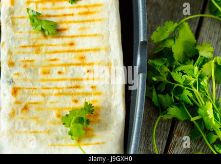 Vegetarische Burritos Wraps mit Bohnen, Avocado und Käse in einer Grillpfanne, Ansicht von oben. Stockfoto