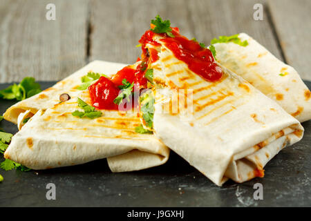 Vegetarische Burritos Wraps mit Bohnen, Avocado und Käse auf einer Tafel. Liebe für eine gesunde vegane Ernährung Konzept Stockfoto