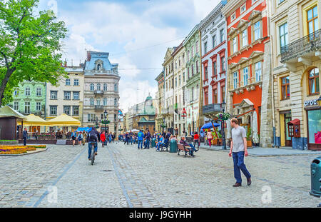 LEMBERG, UKRAINE - 16. MAI 2017: Die Menschen gehen auf dem Marktplatz (Ploschcha Rynok) mit zahlreichen Cafés, Bars und Kaffeehäusern, am 16. Mai in Lemberg. Stockfoto