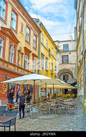 LEMBERG, UKRAINE - 16. MAI 2017: Das Café im Freien in der schattigen armenischen Straße (Virmenska) ist der perfekte Ort zum Entspannen Stockfoto