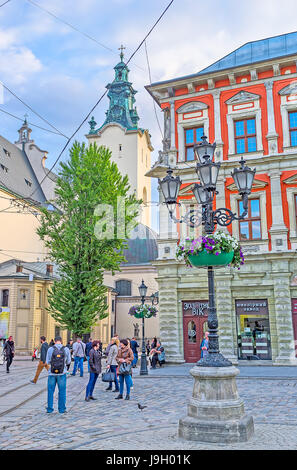 LEMBERG, UKRAINE - 16. MAI 2017: Die malerischen, altmodischen Straßenlaternen mit Blumen in Töpfen schmücken den Marktplatz (Ploschcha Rynok) Stockfoto