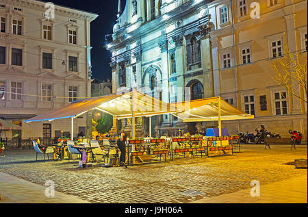 LEMBERG, UKRAINE - 16. MAI 2017: Die gemütliche Außenterrasse des Restaurants ist der perfekte Ort, um den Abend mit Blick auf mittelalterliche Häuser zu verbringen Stockfoto