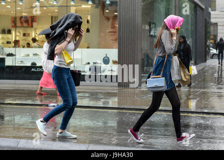 London, UK. 2. Juni 2017. UK-Wetter - Shopper, Pendler und Touristen reagieren auf einem plötzlichen Gewitter bringt einen schweren Wolkenbruch zur Oxford Street. Bildnachweis: Stephen Chung/Alamy Live-Nachrichten Stockfoto