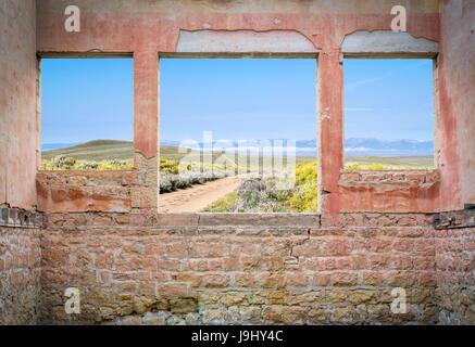 Ranch Straße durch Bergtal gesehen durch Windows von einem verlassenen Haus Stockfoto