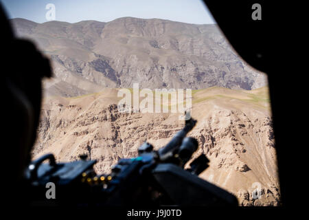 Ein US-Army Tür Schütze die Hügel während eines Fluges in einem UH-60 Black Hawk Hubschrauber, Task Force Griffin, 16. Combat Aviation Brigade zugewiesen Uhren lädt Waffen und Treibstoff vor der Abfahrt auf einer Mission zur Unterstützung der Operation entschlossen unterstützen 1. Mai 2017 in Kunduz, Afghanistan. Kunduz hat erhöhten Aktivität der Taliban als mehr als 8.000 US-Soldaten und 6.000 von NATO und NATO-Staaten weiterhin die Regierung zu unterstützen. Stockfoto