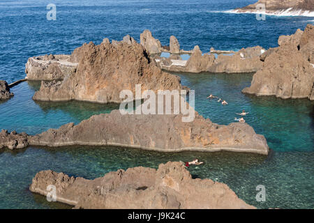 Menschen schwimmen in natürlichen Fels-Pools - Piscinas Verwaltungsbehörde - bei Porto Moniz, Madeira Stockfoto