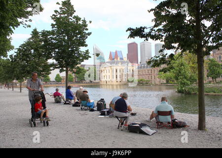 Hobby-Maler sitzen, um die Skyline von Den Haag (The Hague), Niederlande zu malen. Hofvijver Teich blickt Binnenhof, niederländische Parlament. Stockfoto