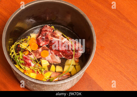 Rindfleisch Knochen Bouillon Suppe kochen Zutaten in Saosepan auf Tisch Stockfoto