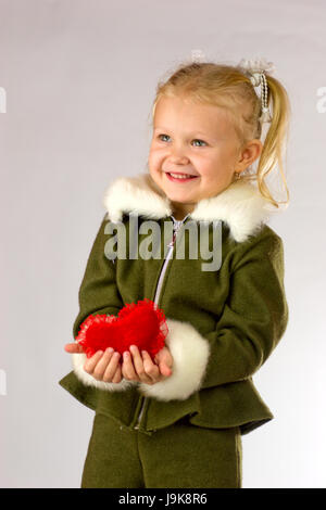 Glücklich lächelnd vierjährige Mädchen, das ihr Herz als Geschenk Stockfoto