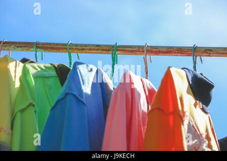 Trockene Tücher und T-Shirt, an sonnigen Tagen auf der Wäscheleine hängen. buntes T-shirt. Stockfoto