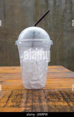 Ein Glas mit Eiswürfeln auf Holz Stockfoto