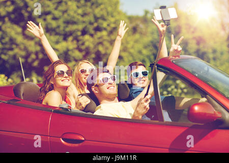 Freunde fahren im Cabrio Auto und nehmen selfie Stockfoto