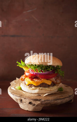 Speck-Käse-Burger mit Rindfleisch Patty, Tomaten und Zwiebeln Stockfoto