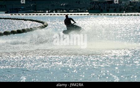 Silhouette eines Mannes auf dem Jet-Ski im Meer mit Wasser spritzt auf der Insel Koh Larn, Pattaya, Chonburi, Thailand. Stockfoto