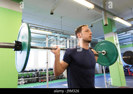 Mann tut Übung mit Langhantel in Turnhalle Stockfoto