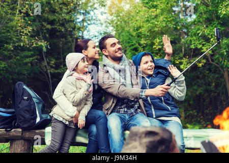 Familie mit Smartphone unter Selfie nahe am Lagerfeuer Stockfoto