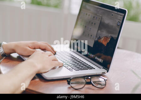 junger Bankangestellter beschäftigt auf einem Laptop in der Mittagspause Stockfoto