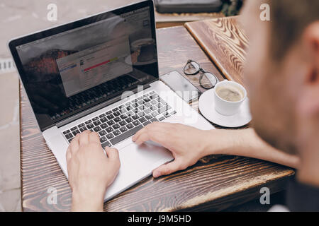 ein junger Bankangestellter beschäftigt auf einem Laptop in der Mittagspause Stockfoto