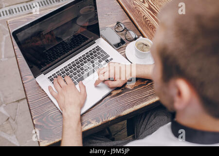 ein junger Bankangestellter beschäftigt auf einem Laptop in der Mittagspause Stockfoto