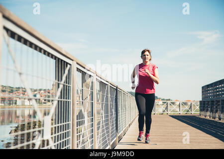 Applying Frau läuft im Freien an einem sonnigen und heißen Tag Stockfoto