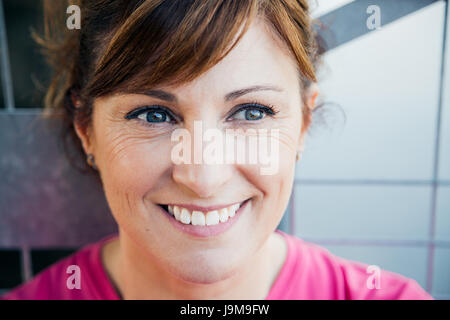Nette verträumte mittleren gealterten Frau Gesicht an einen Zaun gelehnt Stockfoto