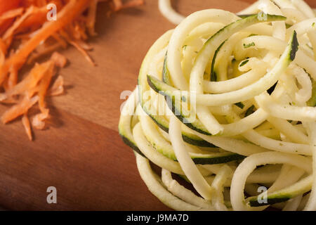 Zucchini-Spaghetti auf Holzbrett Stockfoto