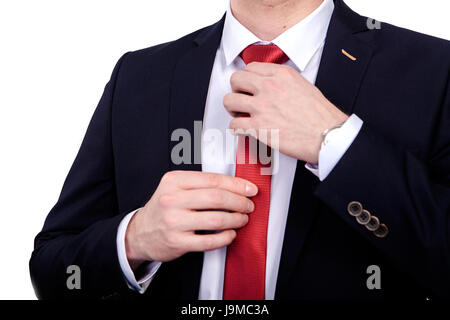 Der Bankier korrigiert die rote Krawatte, mit seinen Händen an seinem Hals auf ein weißes Hemd unter einer schwarzen Jacke. Stockfoto