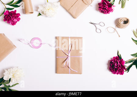 Buch in Geschenkpapier mit Schleife liegt auf einer weißen Tischplatte-Ansicht Stockfoto