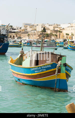Carmelo Padre einem traditionellen maltesischen Fischerboot oder Luzzu, bunt bemalt, im Hafen von Marsaxlokk in Malta Stockfoto
