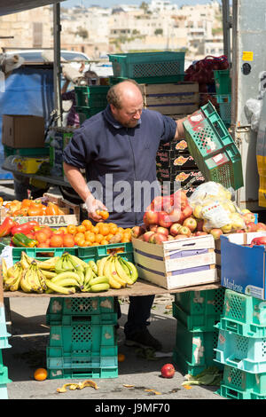 Ein Markt-Händler auf einen Obst- und Gemüse Marktstand auf dem Markt von Marsaxlokk Malta Stockfoto