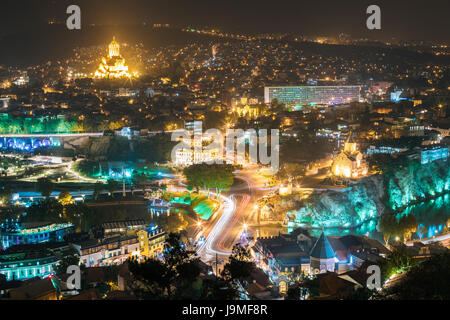 Tiflis (Tbilissi), Georgien. Stadtbild bei Nachtbeleuchtung mit berühmten Sehenswürdigkeiten. Rike Park, die Kathedrale der Heiligen Dreifaltigkeit oder Sameba, armenische Kathedrale Saint George, Stockfoto