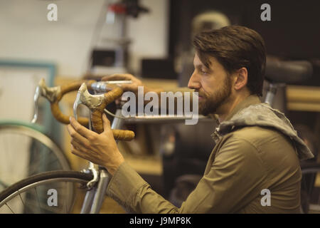 Seitenansicht des fokussierten Mitarbeiter Reparatur Oldtimer Fahrrad Workshop Stockfoto