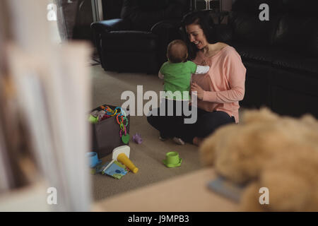 Mutter mit ihrem Baby im Wohnzimmer zu Hause spielen Stockfoto